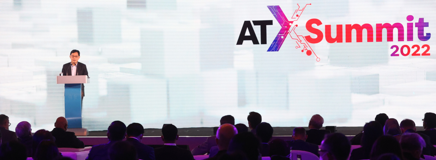 Person at podium addressing audience; "ATxSummit 2022" logo behind.